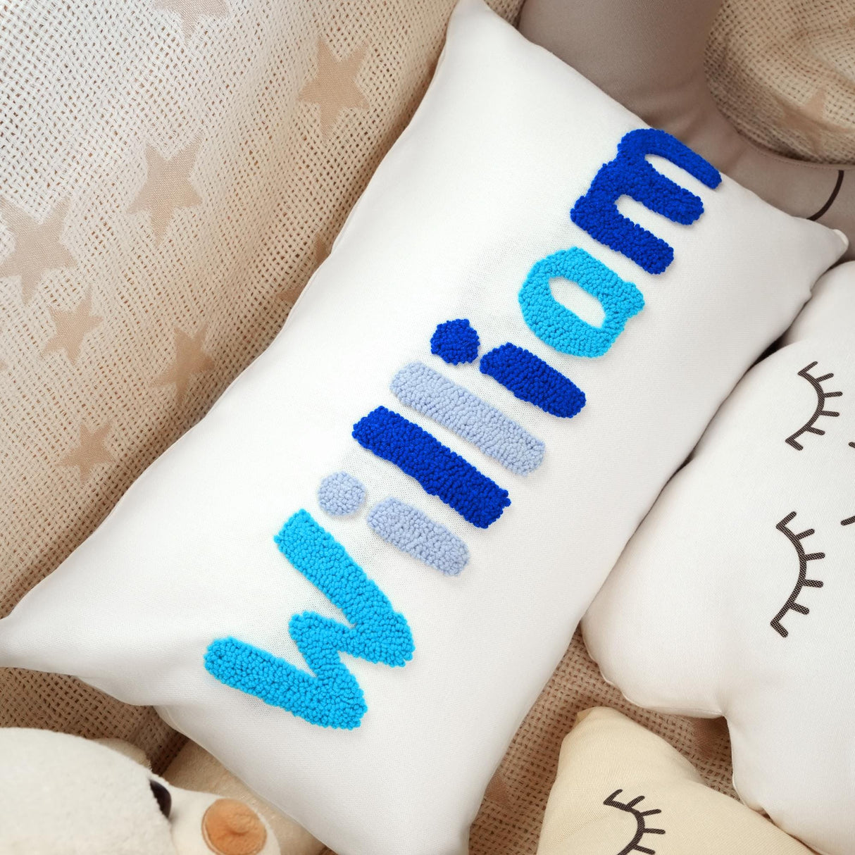 a white pillow with a blue word on it