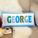 a pillow that says george on it next to a cup of coffee