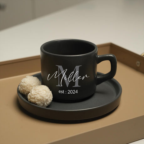 a black coffee cup sitting on top of a tray