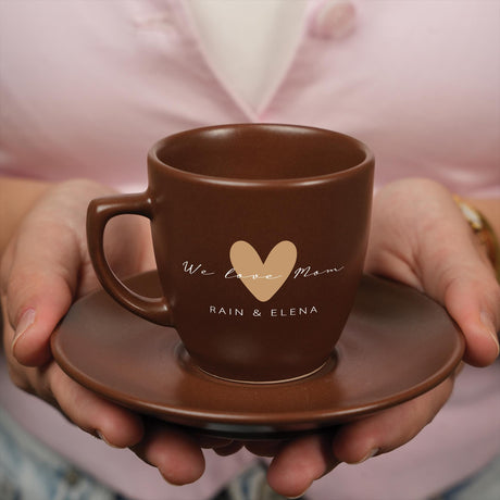 a person holding a coffee cup with a heart on it