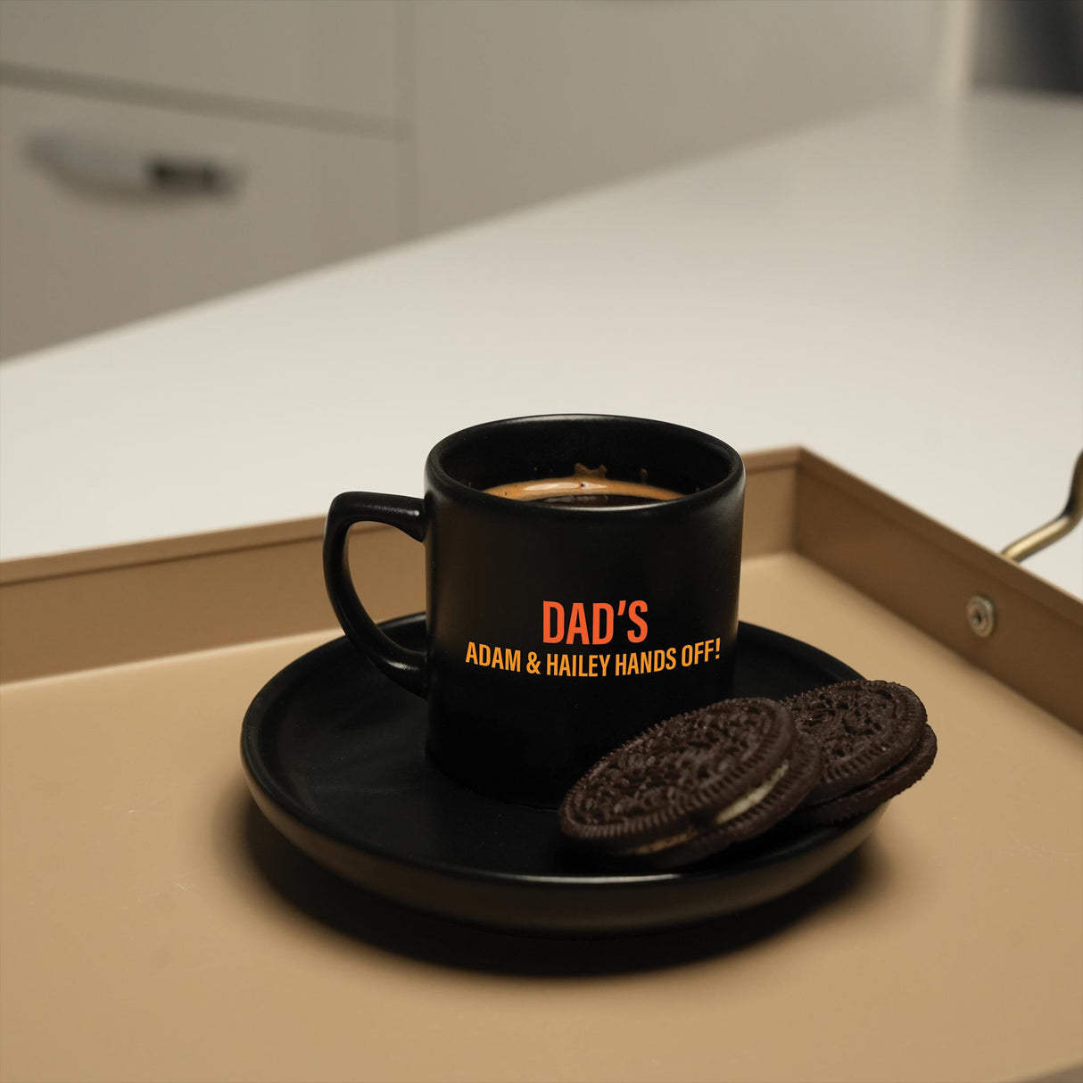 a cup of coffee and a cookie on a tray