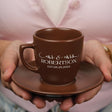 a person holding a coffee cup on a plate