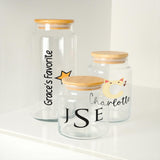 three glass jars with wooden lids on a shelf