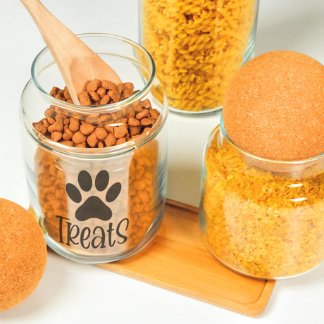 a wooden spoon in a glass jar filled with dog food