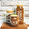 three jars of cat treats sitting on a table