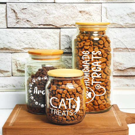 three jars of cat treats sitting on a table