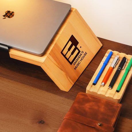 a wooden desk with a laptop and pen holder