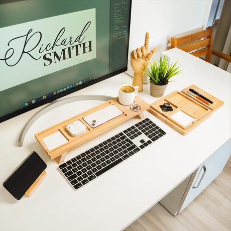 a computer desk with a keyboard, mouse and cell phone