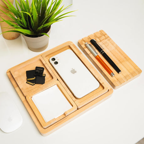 a desk with a cell phone, pen and mouse