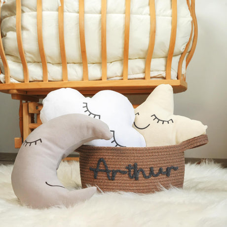 two stuffed animals sitting in baskets with name on them