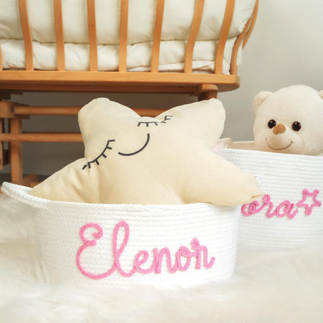 two stuffed animals sitting in baskets with name on them