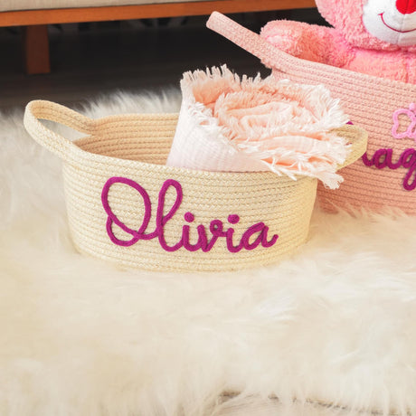 two baskets with a teddy bear and name on them