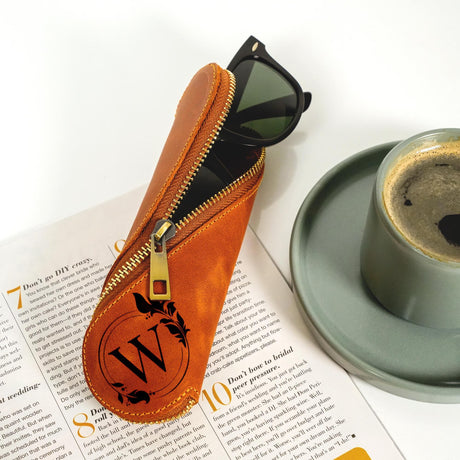 a pair of sunglasses sitting on top of a book next to a cup of coffee