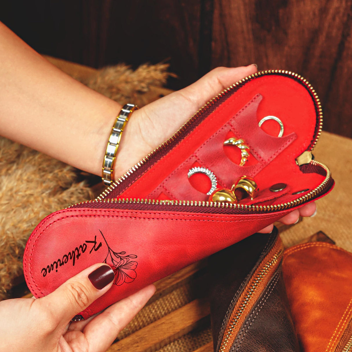 a woman holding a red purse with several rings in it