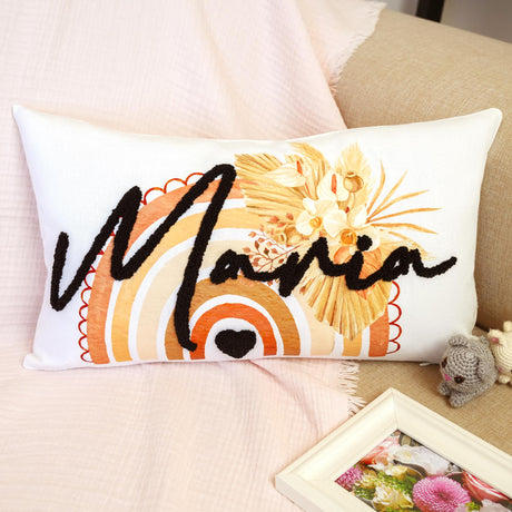 a pillow with a name on it sitting on a bed