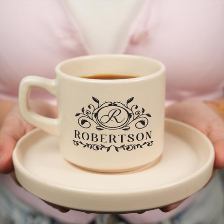 a person holding a cup of coffee on a plate