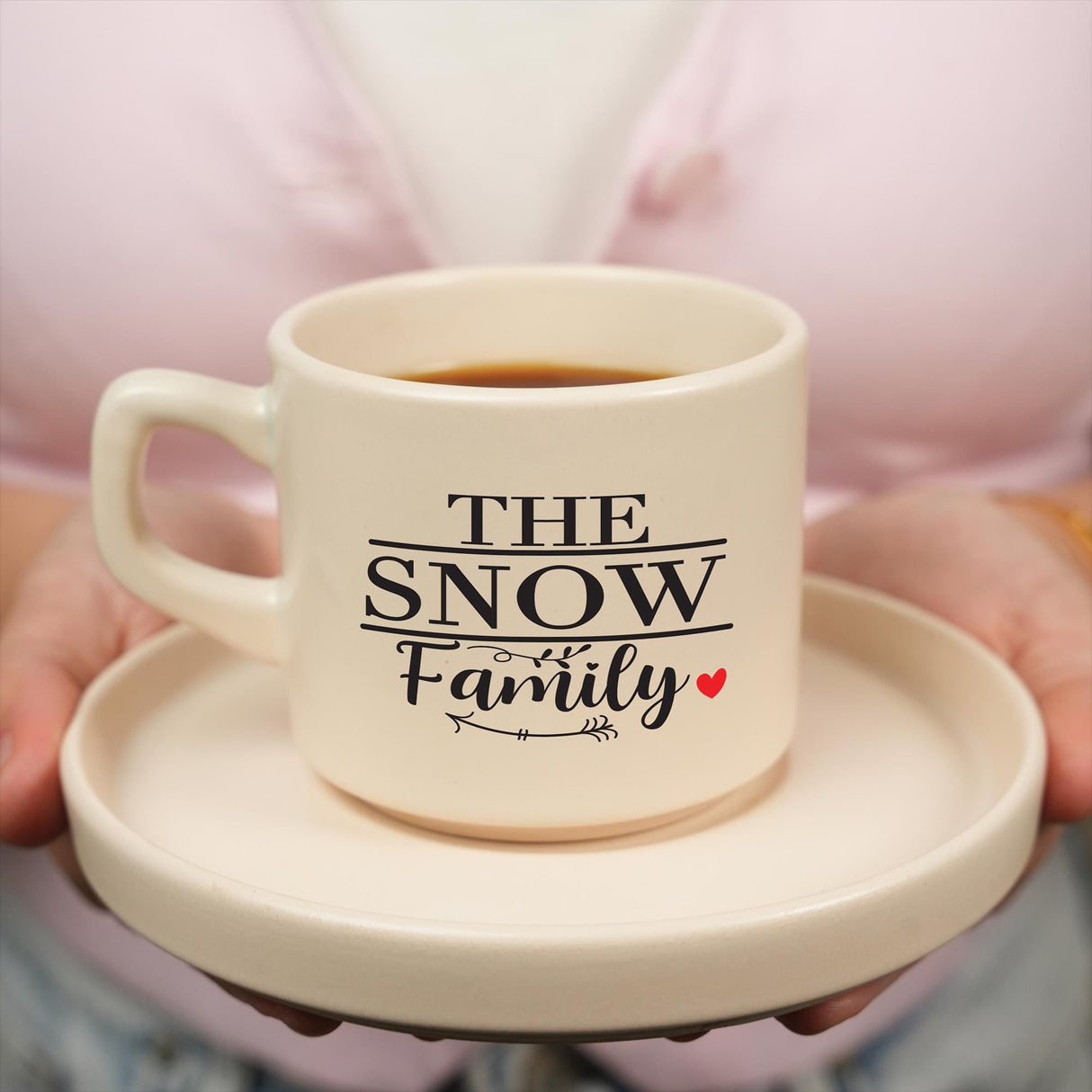 a person holding a coffee mug with the words the snow family on it