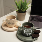 a cup of coffee sitting on a saucer next to a laptop