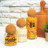 a couple of jars filled with pasta next to a potted plant