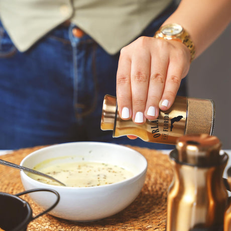 a woman pouring a bowl of soup into a white bowl